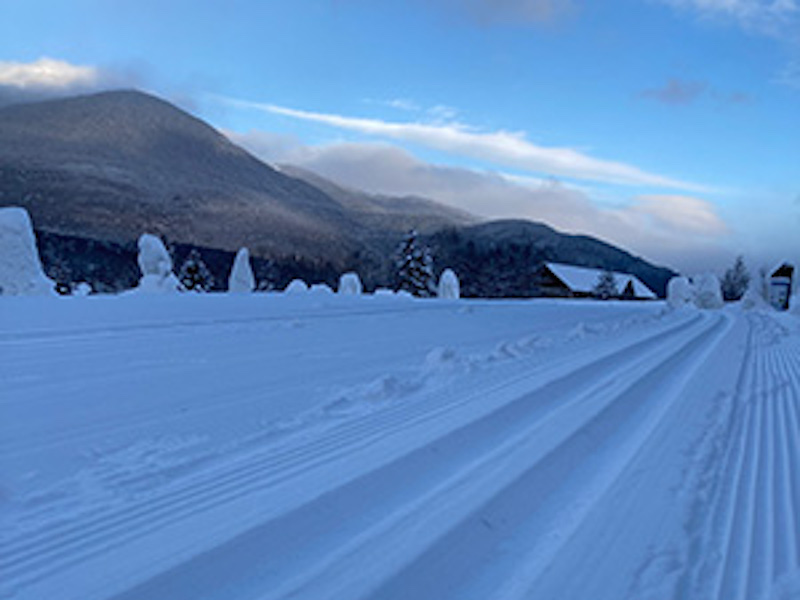 Freshly groomed ski trails with White Mountains in the background at Great Glen NH
