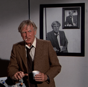 Lloyd Bridges in movie 'Airplane!',with cup of coffee and cigarette, in front of photos showing him in exactly the same pose.