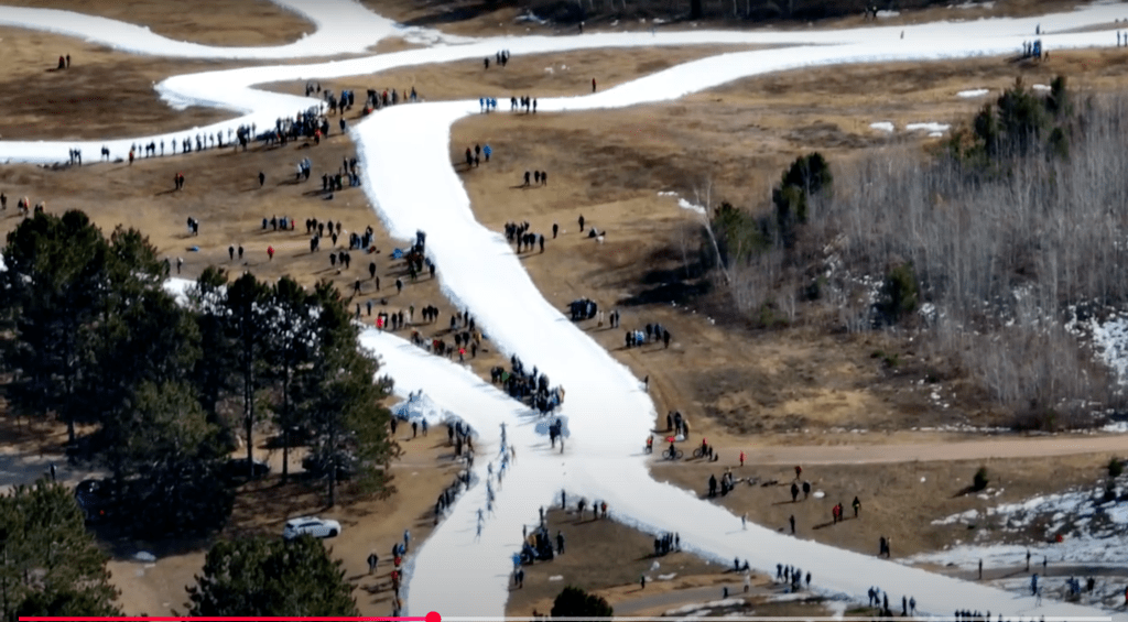 Screenshot of aerial footage from 2024 North American Birkebeiner, showing manmade ski trails loping around and across bare ground. From 'American Birkie 2024 Drone Recap'